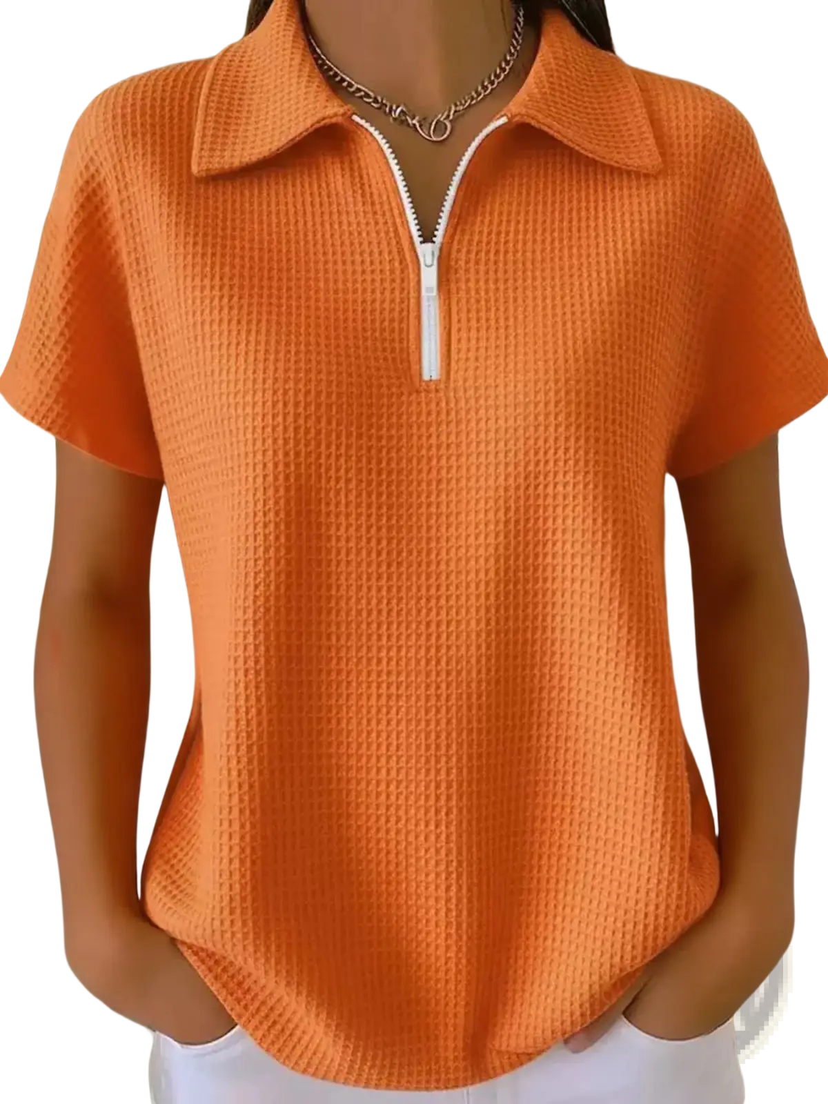 Orange waffle knit half zip short sleeve polo shirt with white zipper and collar made of textured knit fabric
