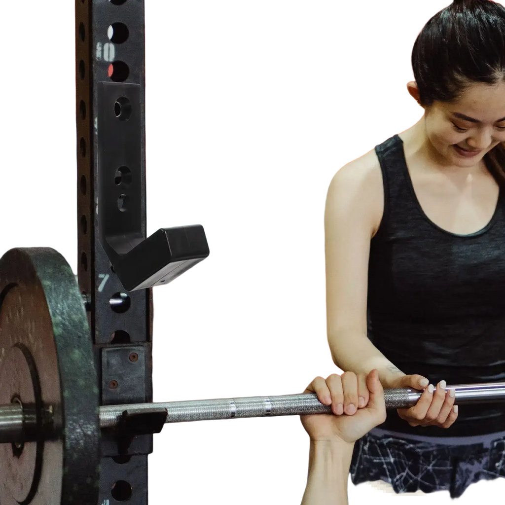 Black wall mounted barbell storage rack holding a silver metal shaft barbell with dark worn weight plates