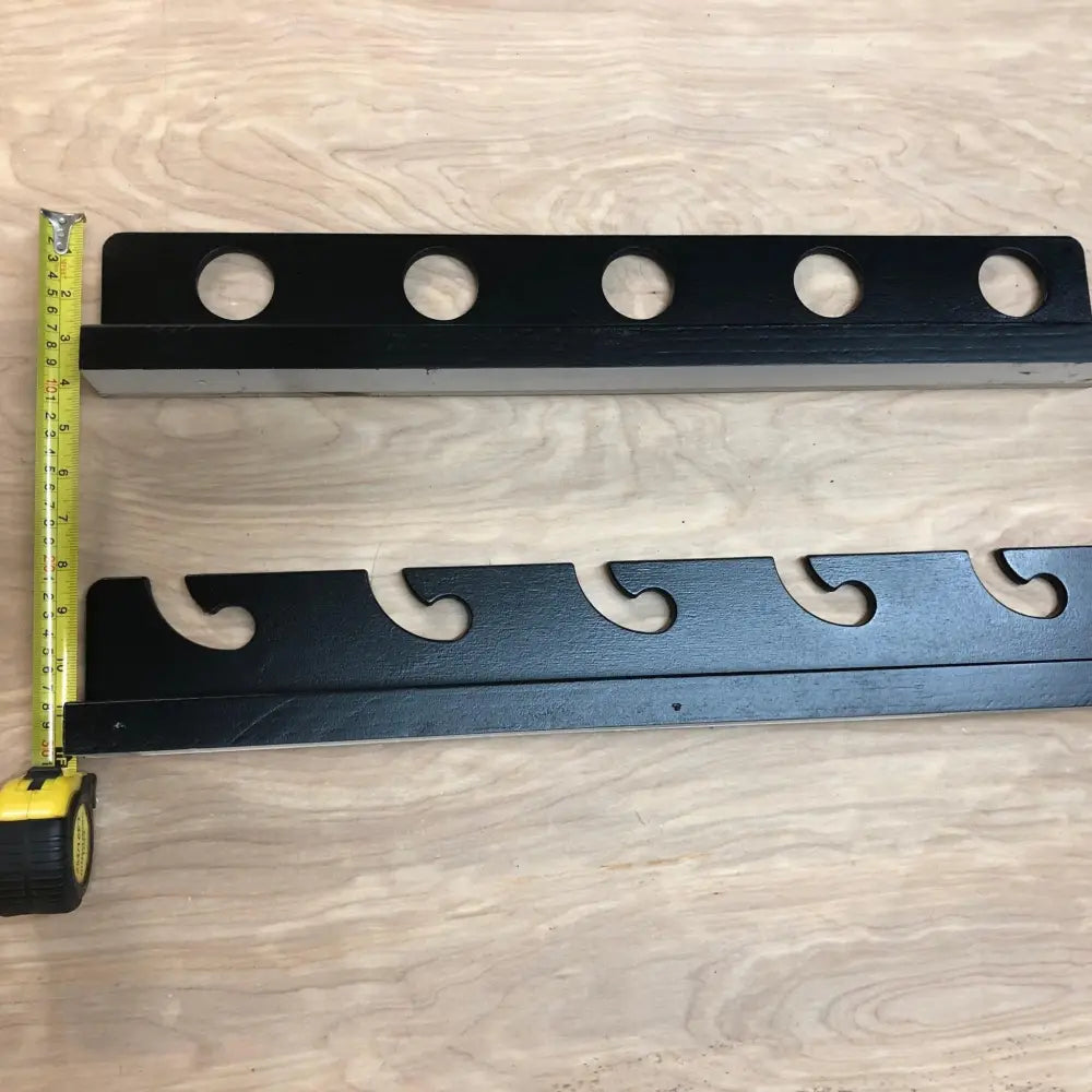 Black wooden Wisa birch wave wall mounted fishing rod rack with five circular cutouts and curved design for holding rods