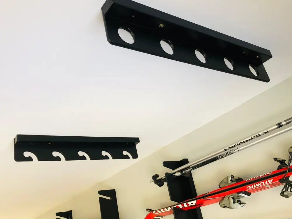 Black wall-mounted wisa birch wave fishing rod rack with circular curved cutouts for holding skis and poles