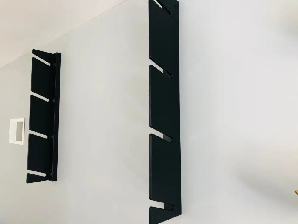 Black birch plywood wall mounted four pair ski and pole rack with sleek modern design and minimalist cutouts