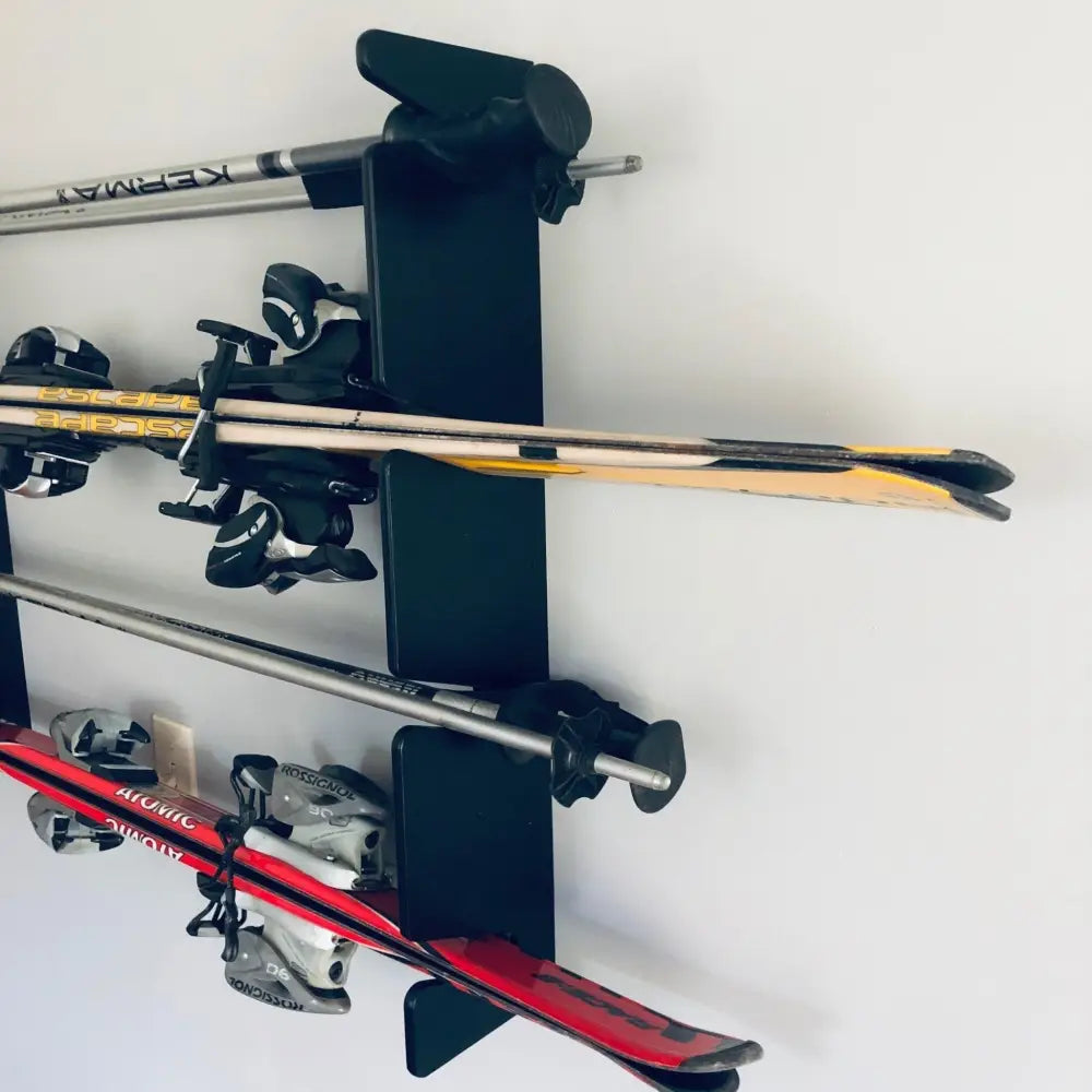 Black birch plywood wall mounted ski rack holding four pairs of skis and poles for organized storage