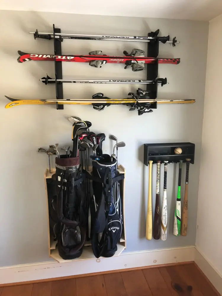 Birch plywood wall mounted four pair ski and pole rack in black holding red silver and yellow skis with bindings