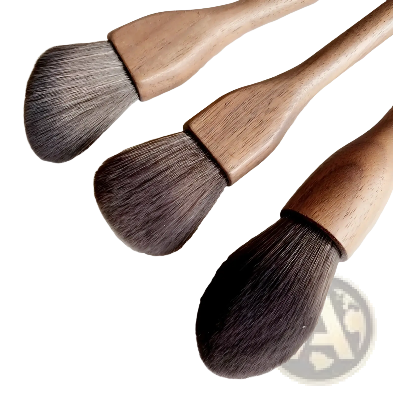 Three wooden-handled walnut wood makeup brushes with dense dark brown soft fiber bristles arranged diagonally