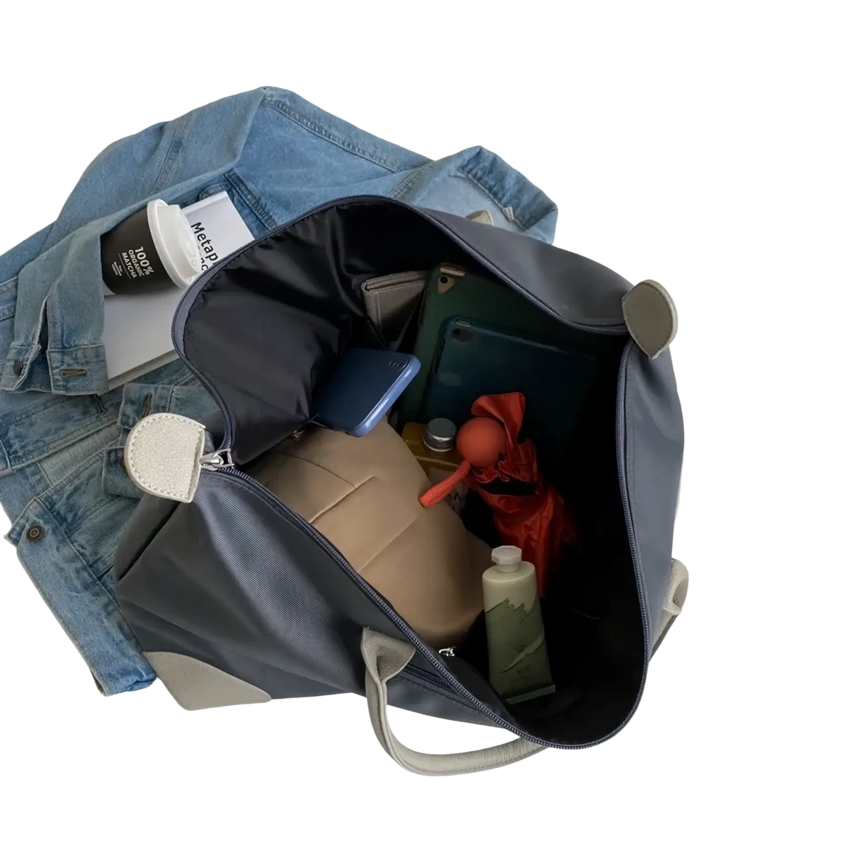 Gray waterproof oxford cloth travel tote bag with white leather-like handles and zipper pulls filled with personal items