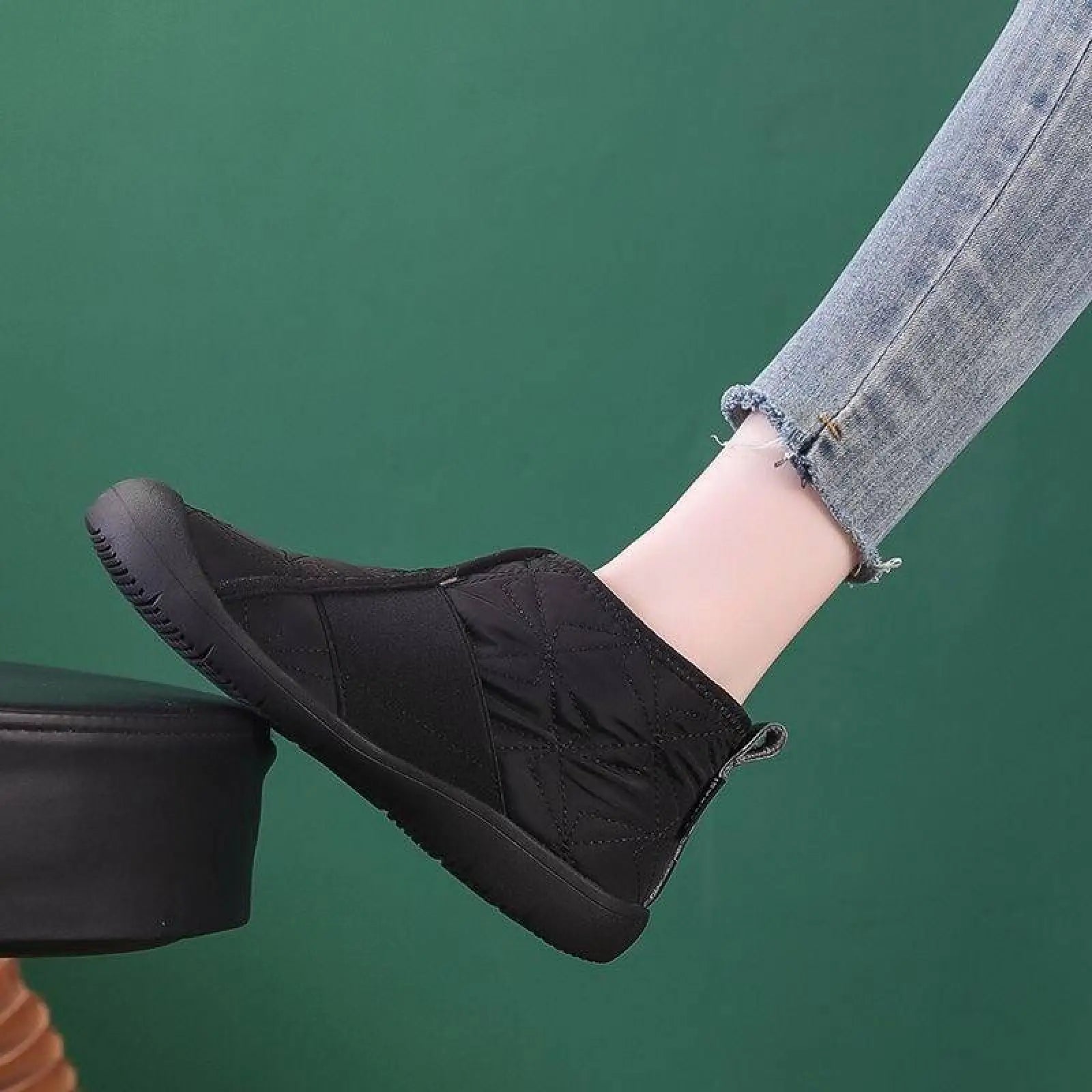 Black quilted waterproof plush winter ankle boot with rubber sole and zipper closure for snow use