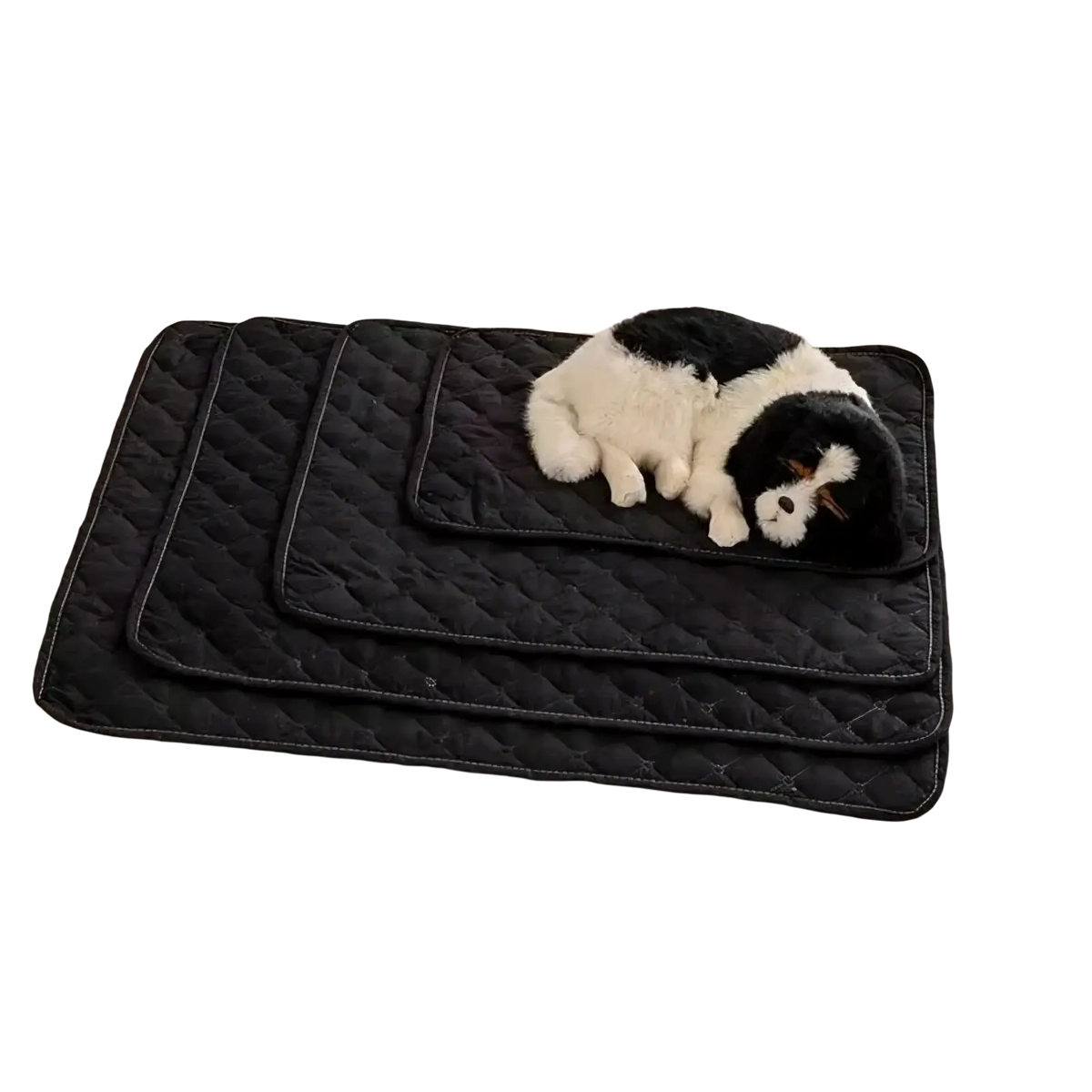 Black quilted waterproof pet bed mat and furniture protector with plush black and white dog toy resting on it