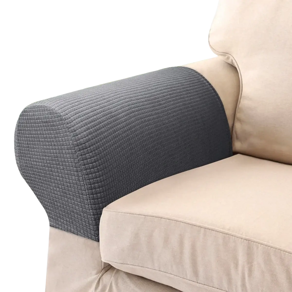 Dark gray spandex waterproof stretch armrest cover snugly fitted over a beige sofa arm with textured fabric