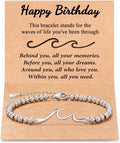 Silver stainless steel wave bracelet with beaded chain and clasp displayed on a birthday card for women gift