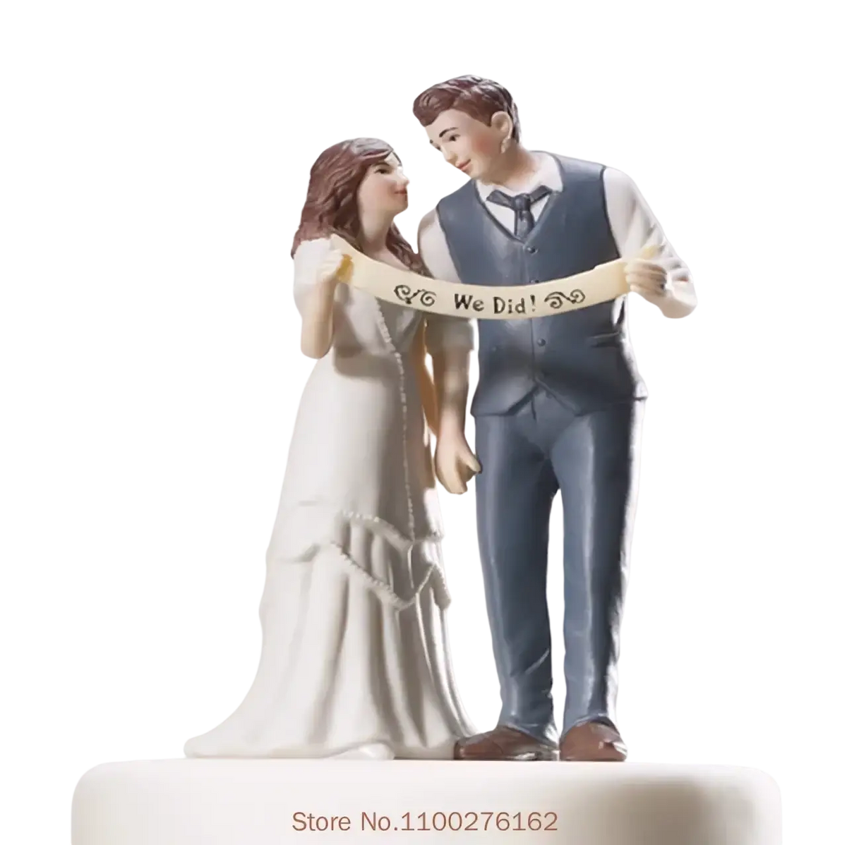 A ceramic wedding cake topper resin figurine of a bride in white gown and groom in blue vest holding we did banner