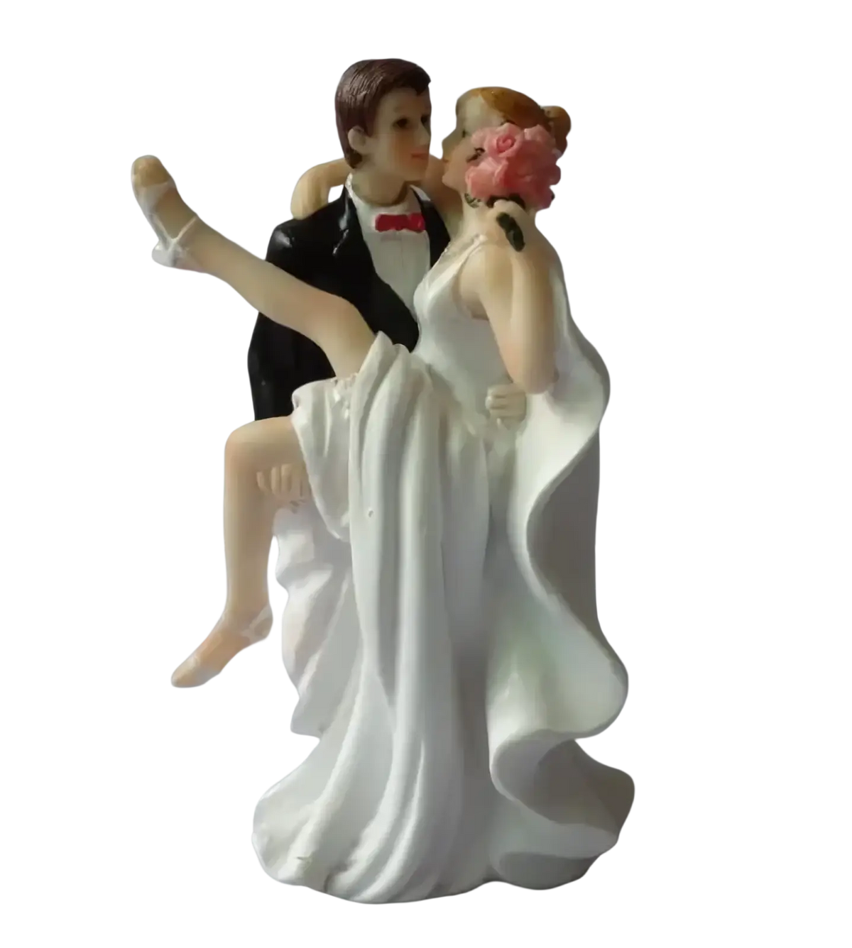 White resin wedding cake topper featuring a groom in black tuxedo with red bow tie and bride in white gown holding pink bouquet