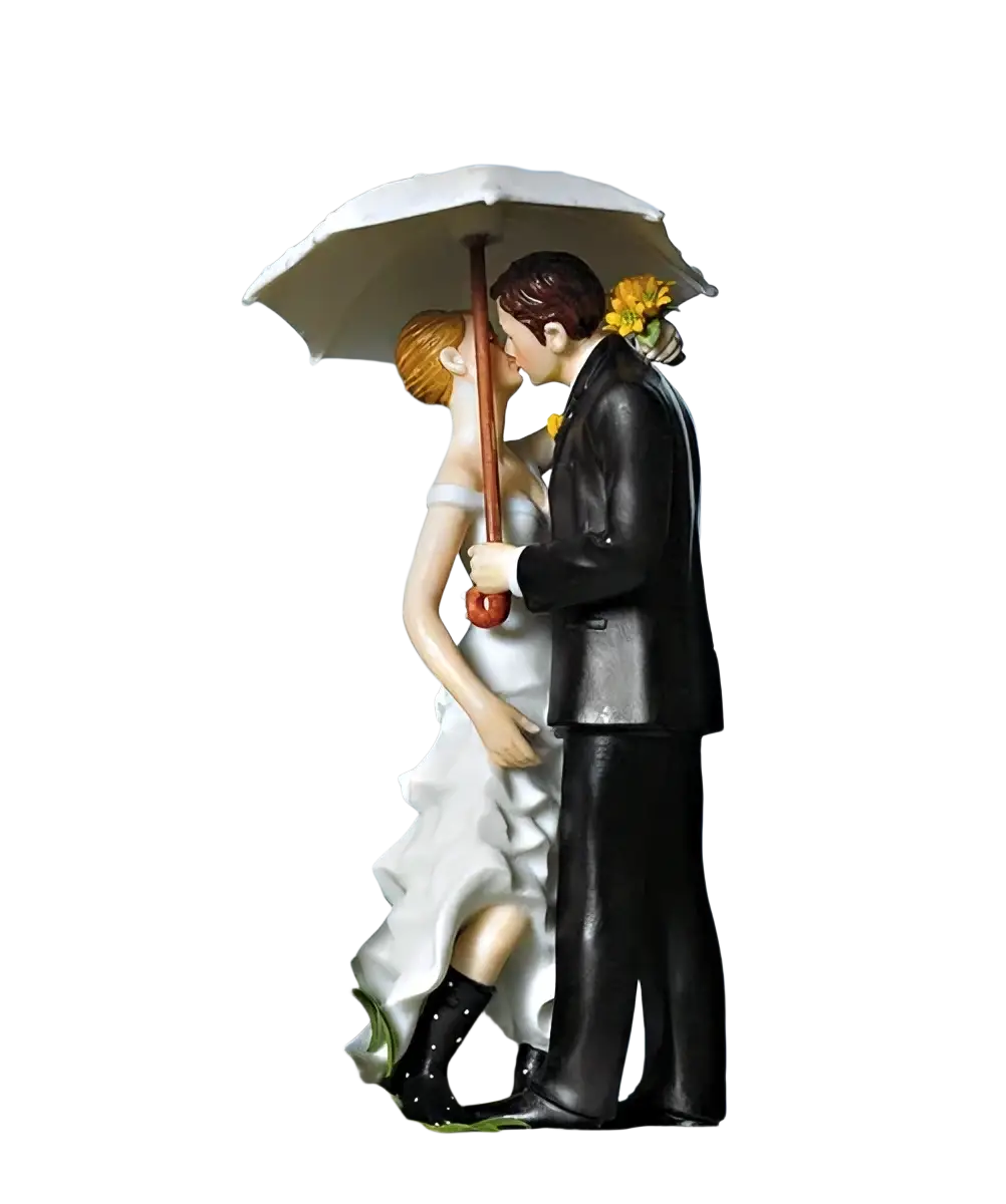 Wedding cake topper bride and groom resin figurine in white and black featuring couple sharing umbrella kiss