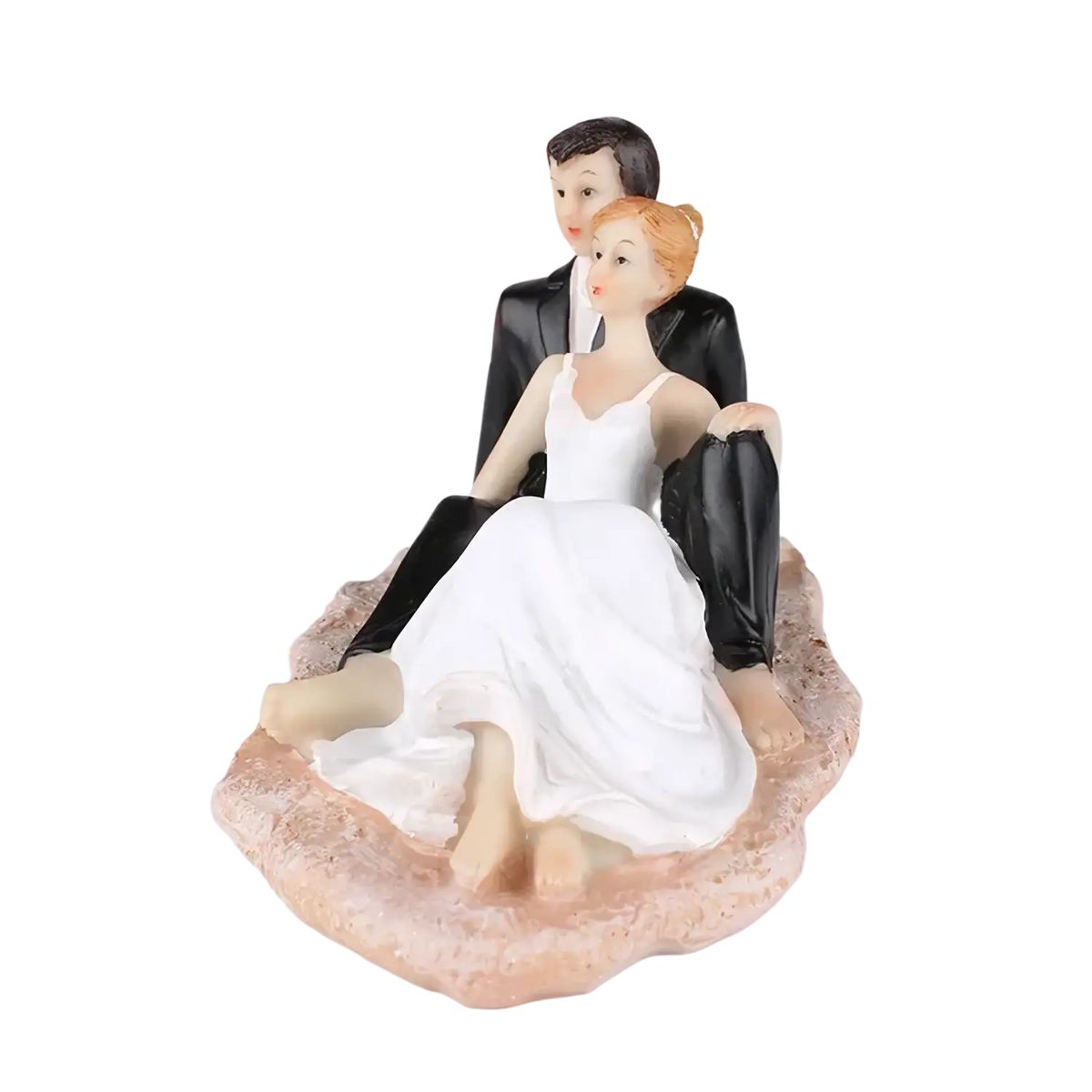 White and black resin wedding cake topper featuring bride in white gown and groom in black suit on pinkish base
