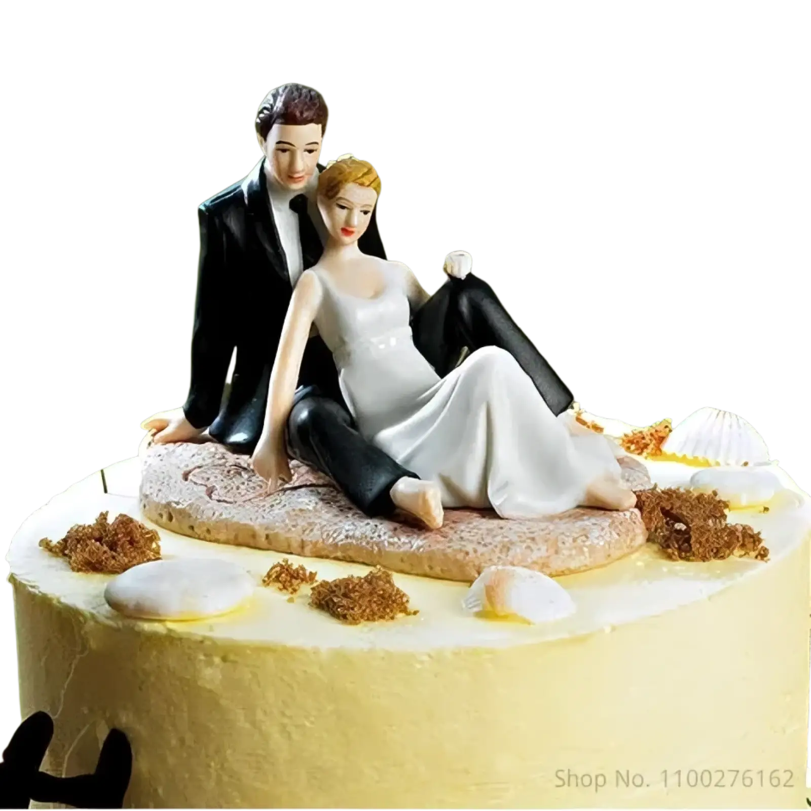 Wedding cake topper bride and groom resin figurine featuring white gown and black tuxedo seated on sandy base with seashells