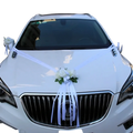 White wedding car decorated with artificial white floral arrangements and ribbons for wedding car decoration set