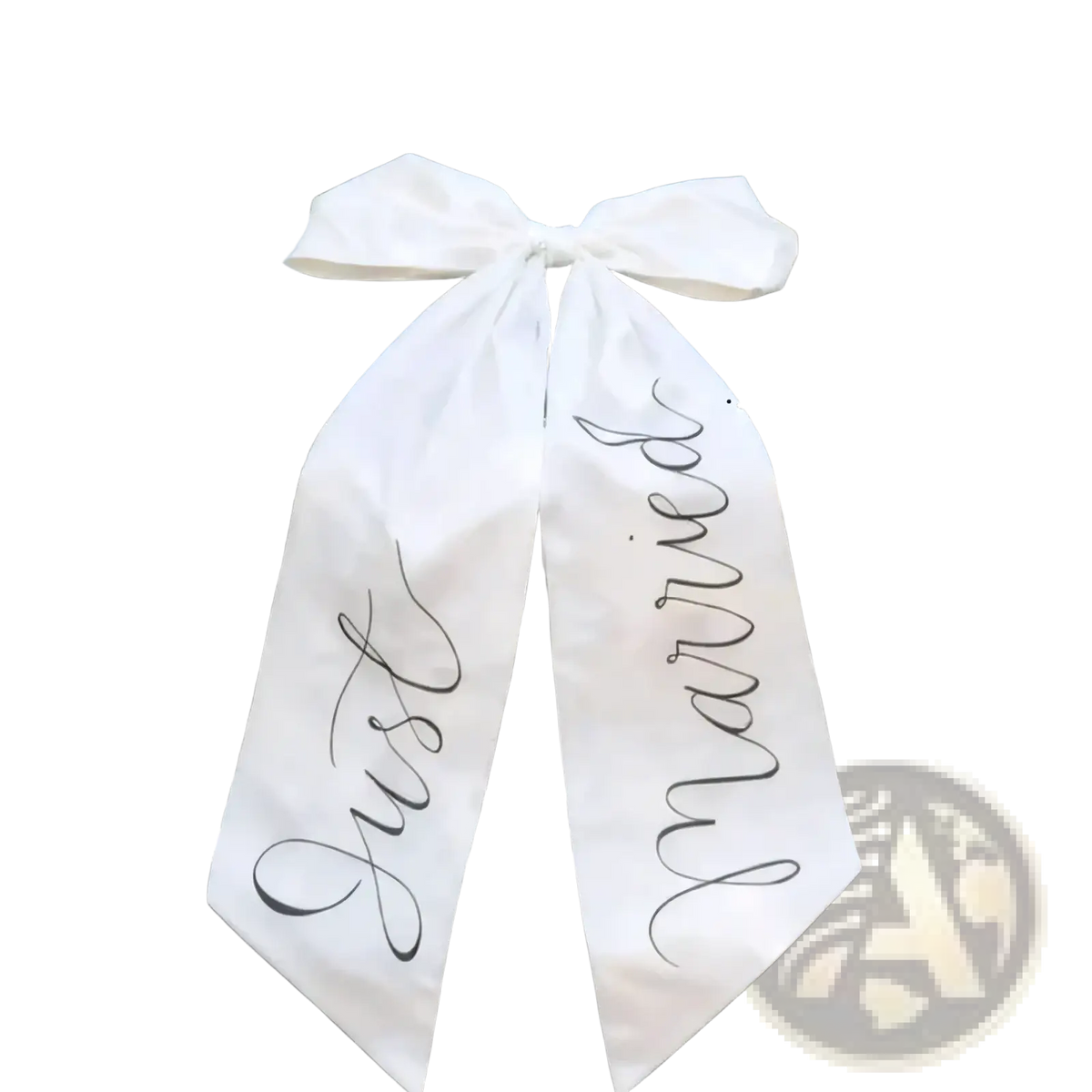 A white satin bridal car bow with just married scripted in black cursive tied across the front of a dark luxury vehicle