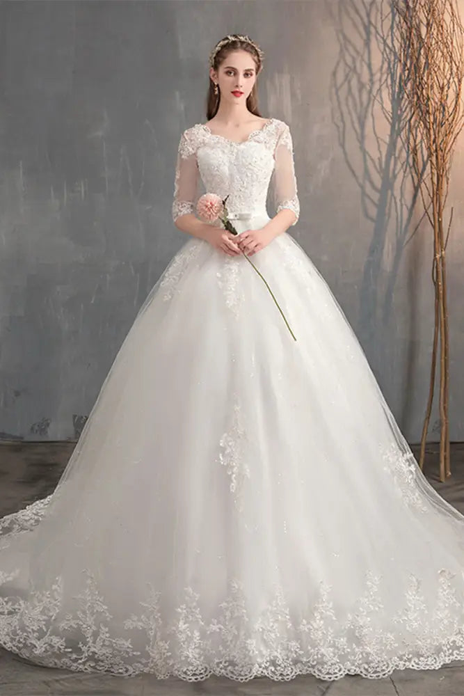 A white lace v neck high waist wedding dress with three quarter length trailing sleeves and a voluminous skirt