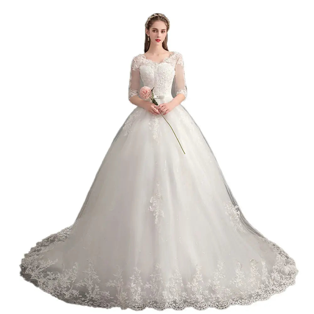 Elegant ivory lace v neck high waist wedding dress with intricate bodice detailing and voluminous tulle skirt