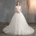 A white lace v neck high waist wedding dress with three quarter length trailing sleeves and a voluminous tulle skirt