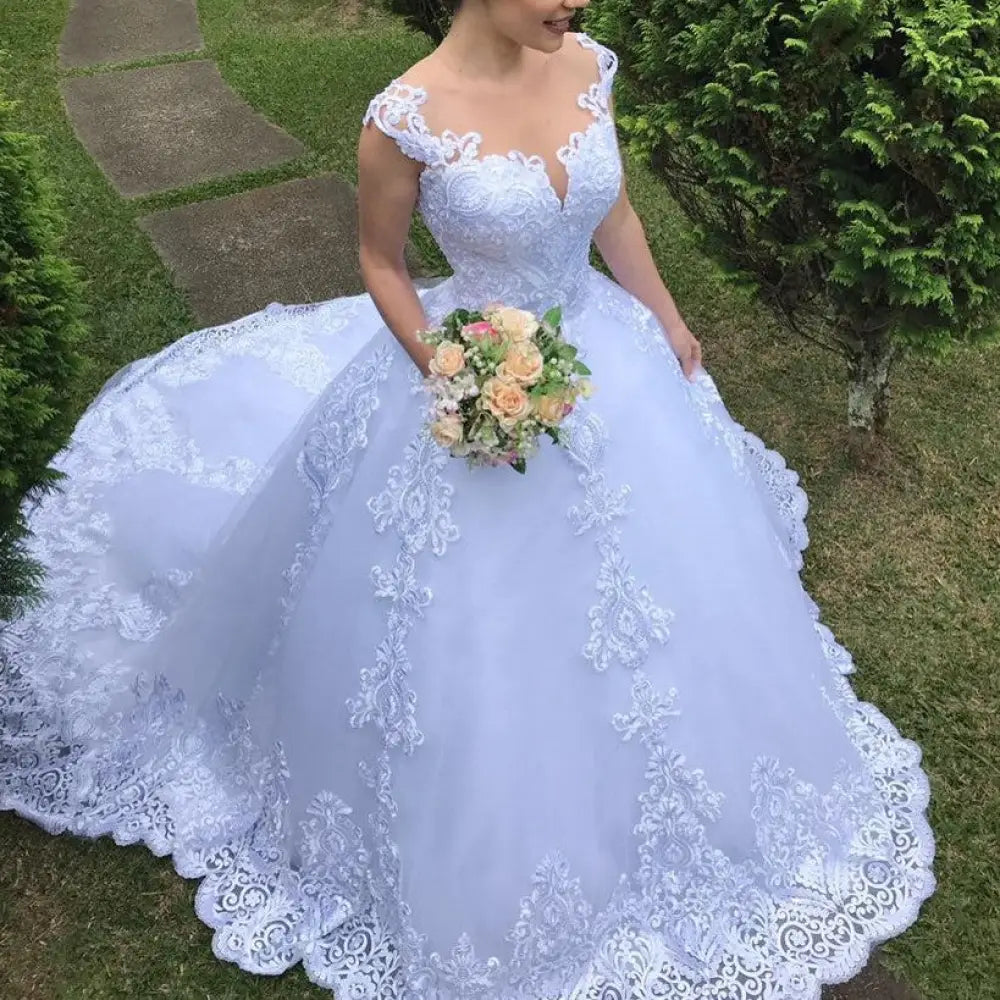 A flowing lavender wedding gown with intricate white lace detailing and a voluminous skirt for vintage bridal elegance