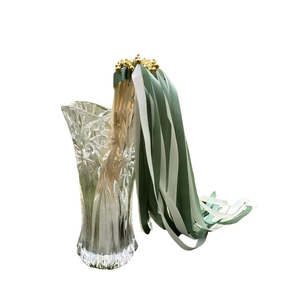 A clear intricately cut glass vase holding decorative wedding ribbon wands with sage green and white stripes 50 pack
