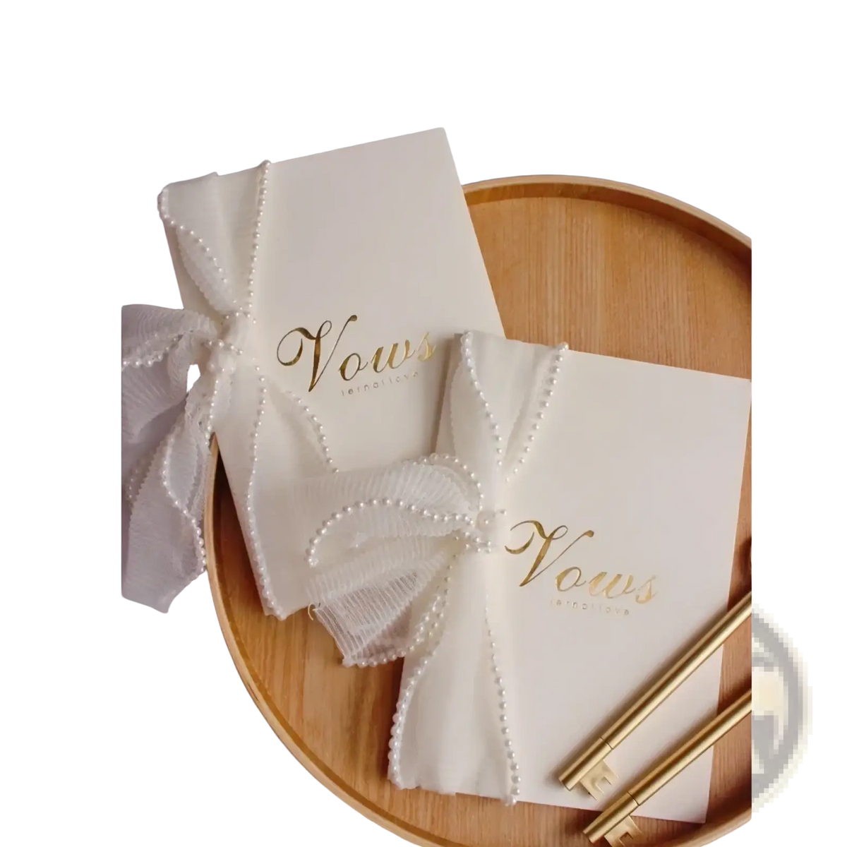 Cream-colored wedding vow book with gold foil lettering and a pearl-trimmed sheer ribbon bow for ceremonies