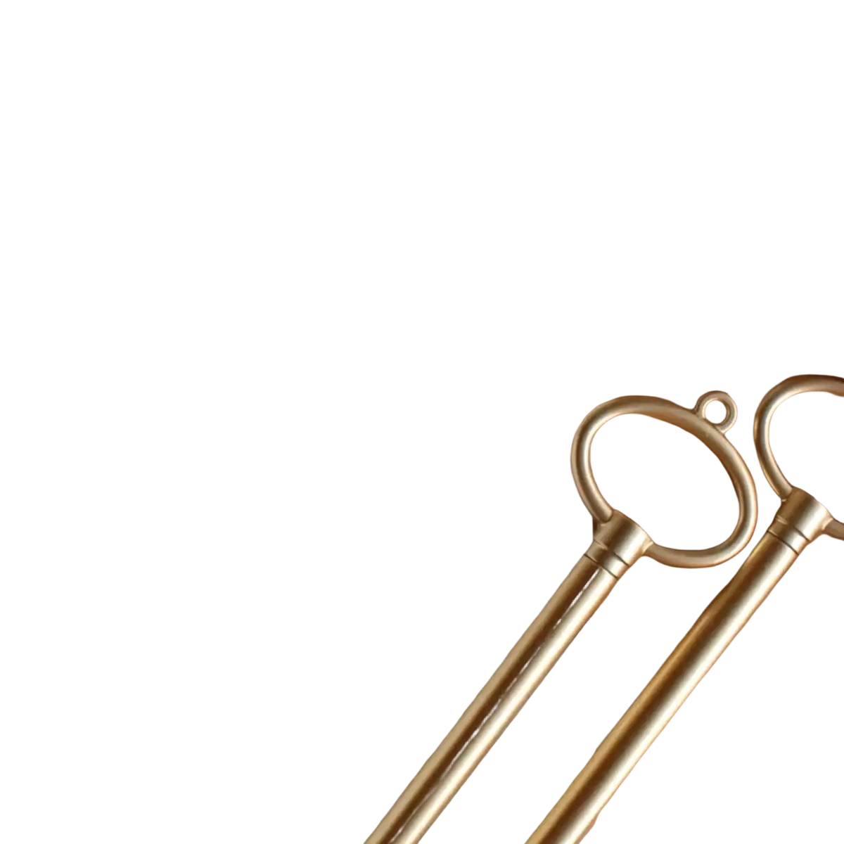 Two elegant gold-toned brass keys with circular ring handles on wooden surface for wedding vow books set
