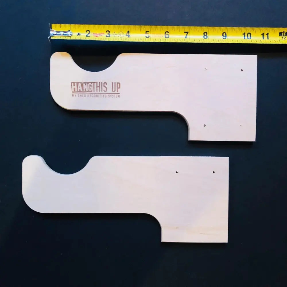 White wooden child safety mounting brackets with hang this up branding for stud mounted wall rack for string trimmers and tools