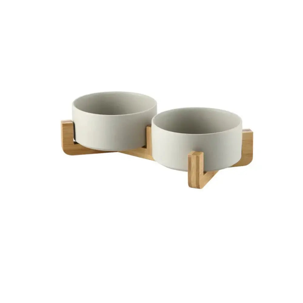 Minimalist matte ceramic pet bowl set in white mounted on a light wood stand for elevated feeding