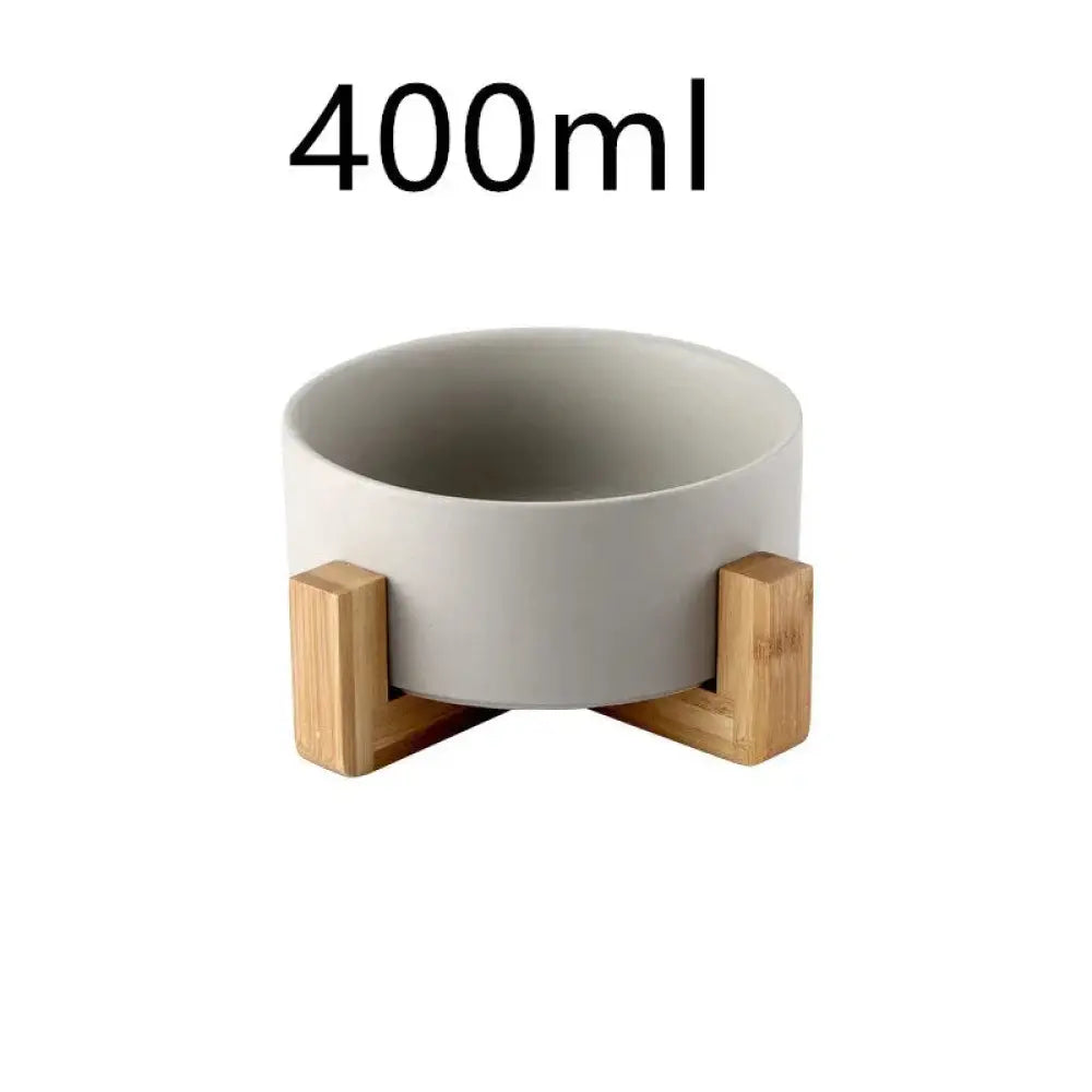 Minimalist matte 400ml ceramic bowl with a gray finish supported by three light wood stands in a set