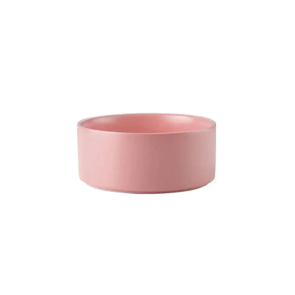 A sleek matte-finished pink ceramic bowl from the minimalist matte ceramic bowl set with wooden stands