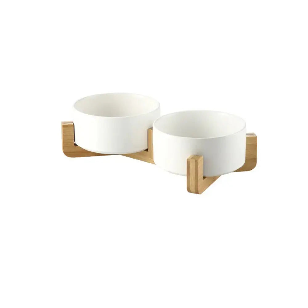 White ceramic pet bowls with a minimalist matte finish mounted on a light wood stand for stylish feeding