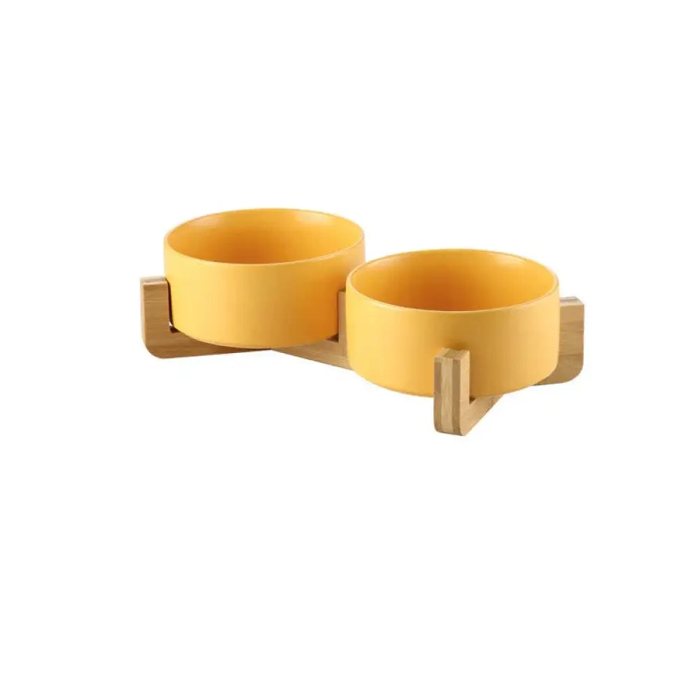 Yellow matte ceramic pet bowl set mounted on a light wood stand for minimalist home decor and functionality