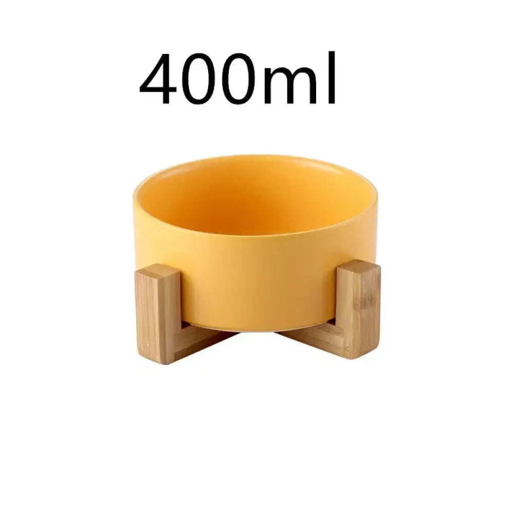 A vibrant yellow minimalist matte ceramic bowl with a light wood stand for modern tableware display