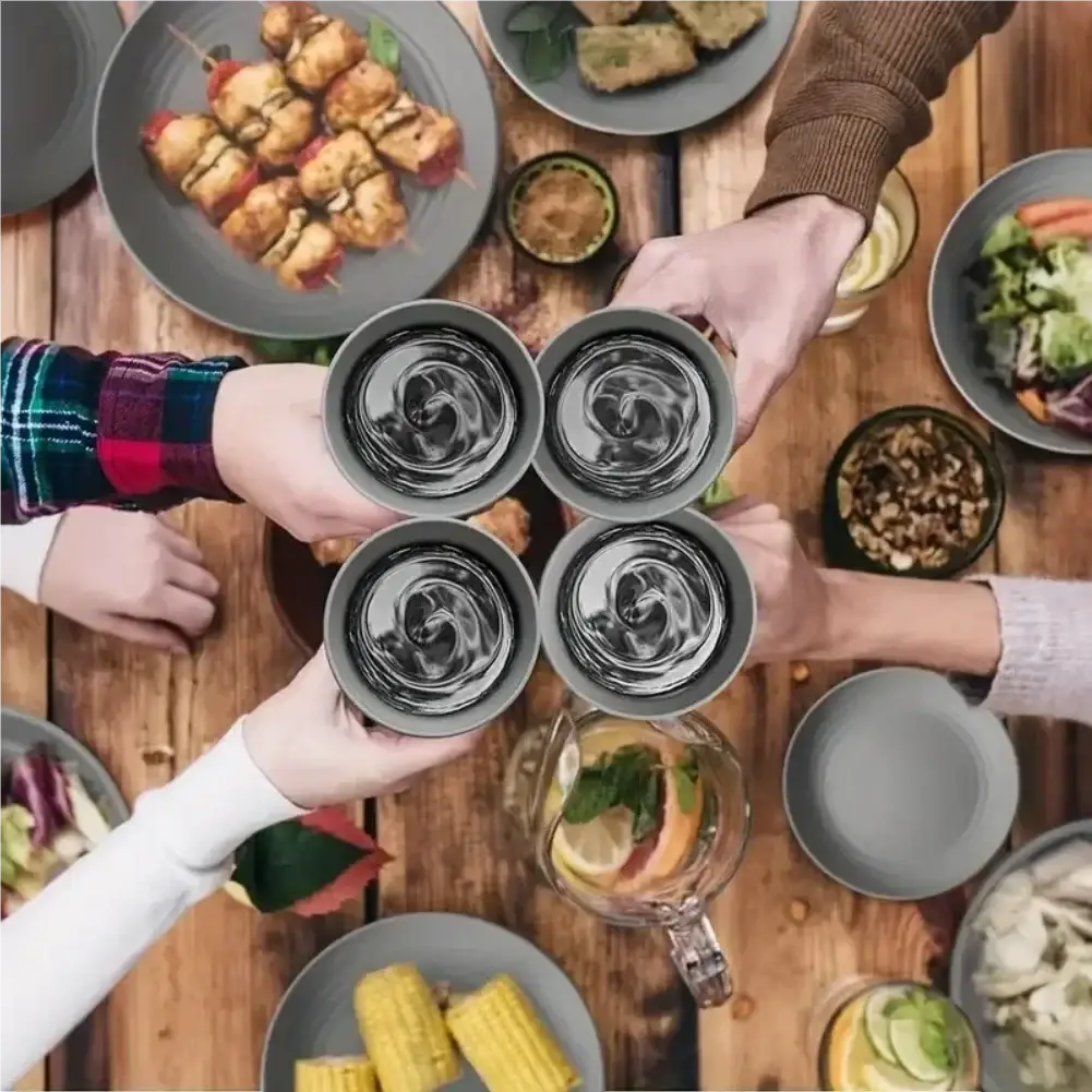 Four gray ceramic wheat straw mugs with swirling liquid reflections held together in a toast from a 16-piece dinnerware set