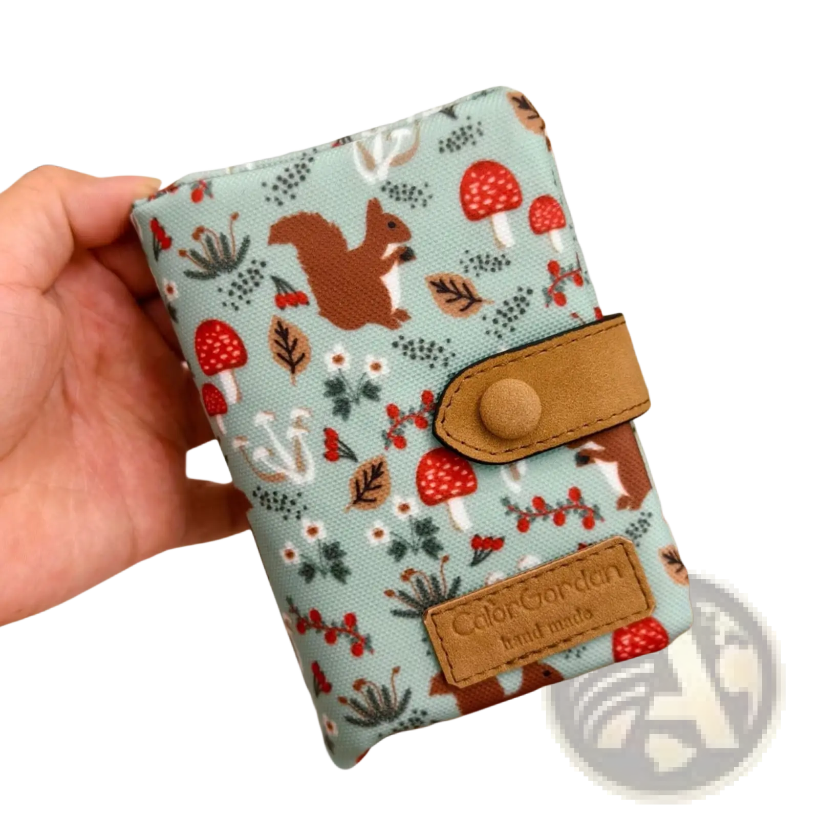 A light blue canvas tri fold multi card wallet featuring a whimsical forest pattern with squirrels and mushrooms