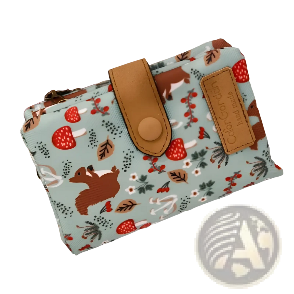 A light blue canvas tri fold multi card wallet with whimsical forest pattern and tan leather accents by Whimsical Patterned