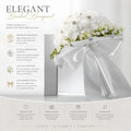White bridal bouquet with delicate white foam roses adorned with pearls and rhinestones tied with satin ribbon bow