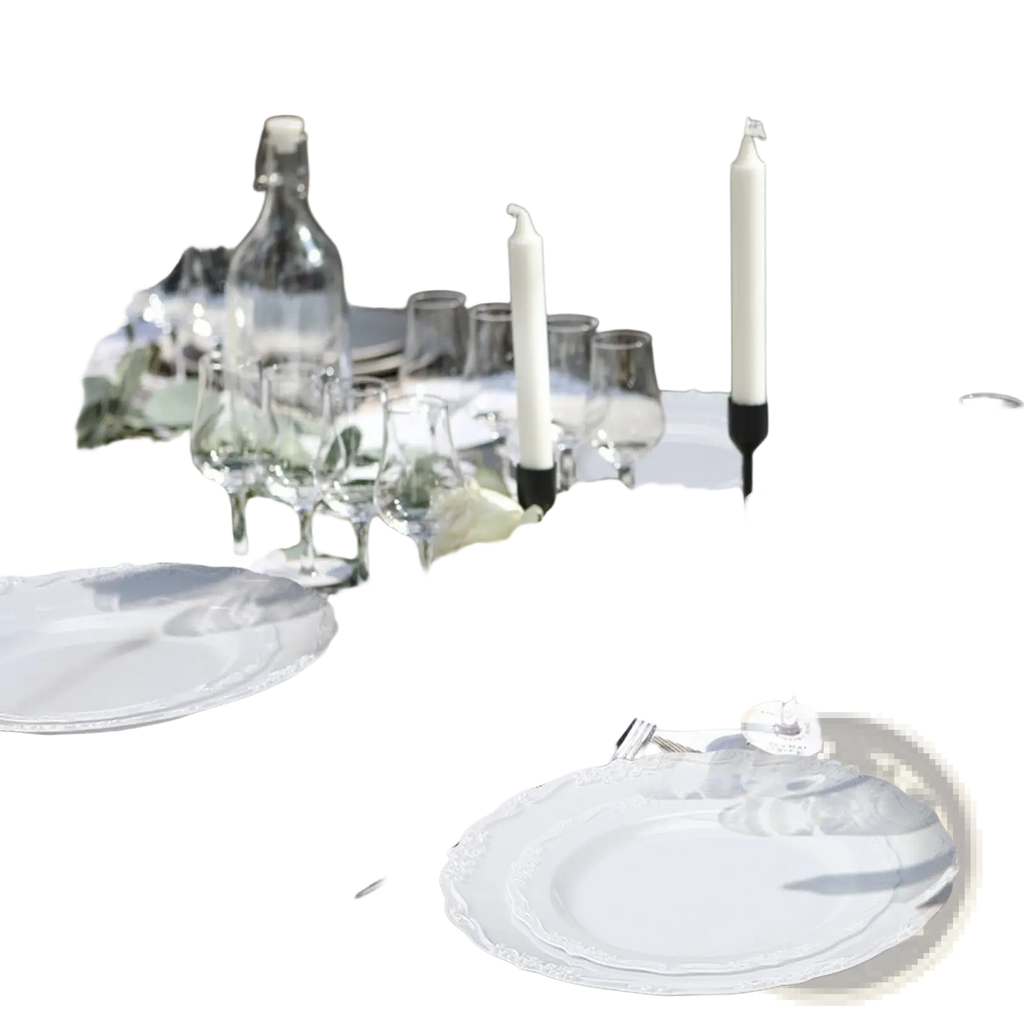 Elegant white ceramic plates with delicate scalloped edge arranged for outdoor dining in a 100 piece lace design set
