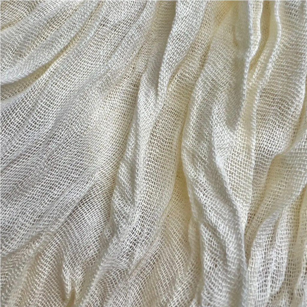 White crinkle scarf made of off-white loosely woven fabric with subtle sheen and visible texture for summer accessory