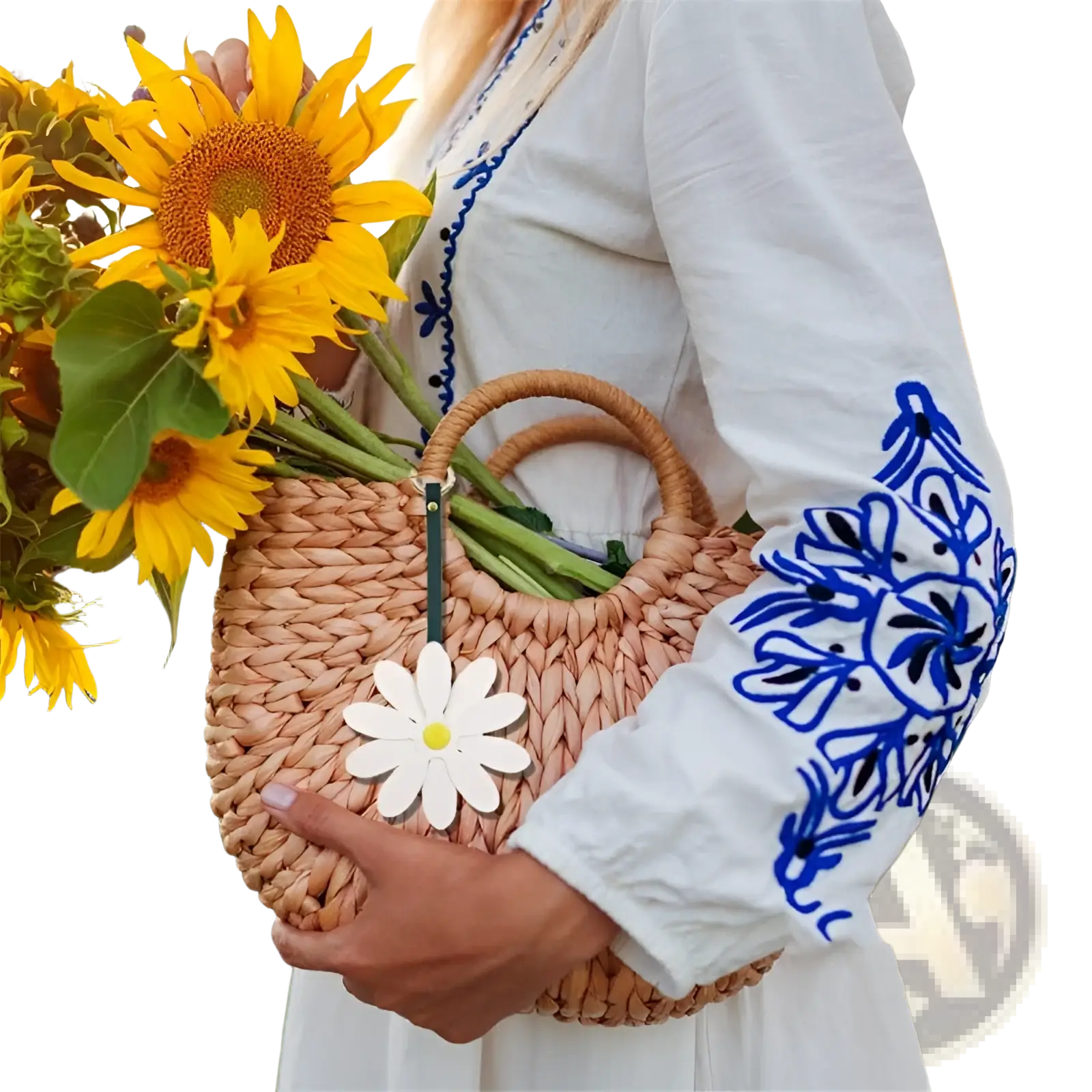 Beige woven straw handbag with natural wood handles featuring a white daisy leather bag charm keychain pendant