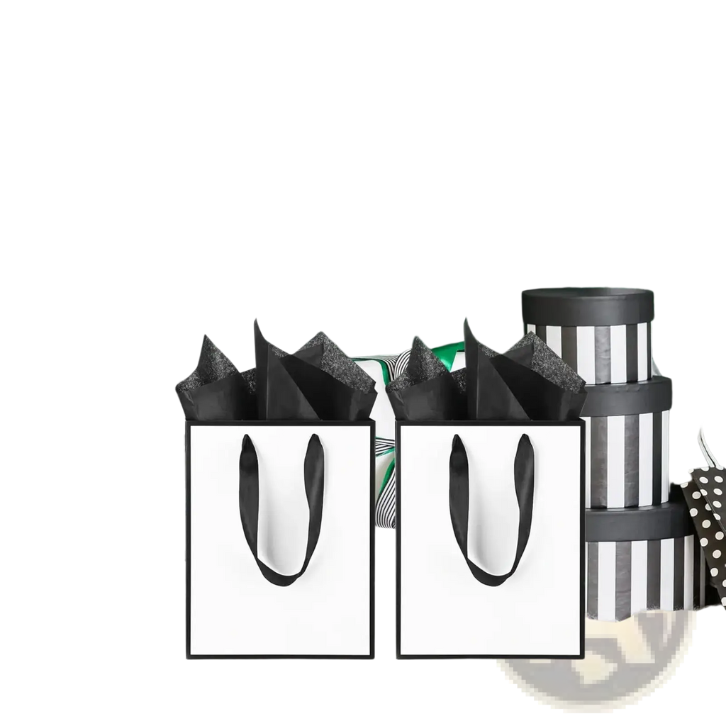 Two white gift bags with black ribbon handles and thin black borders filled with crinkled black tissue paper