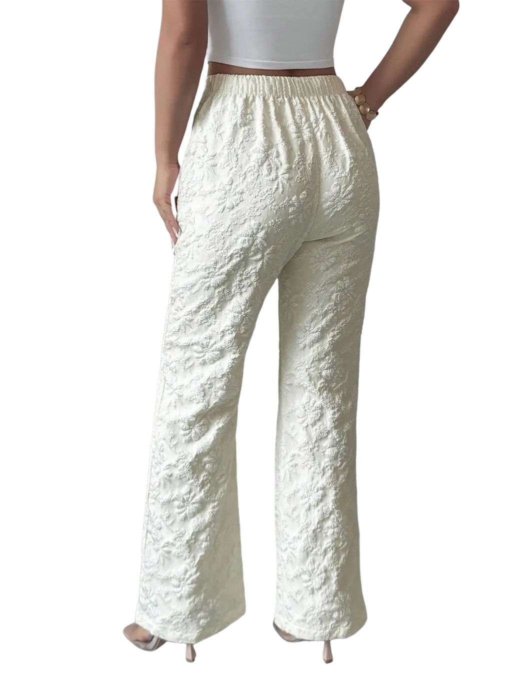 Cream-colored high waisted wide leg pants with intricate floral embroidery and an elastic waistband