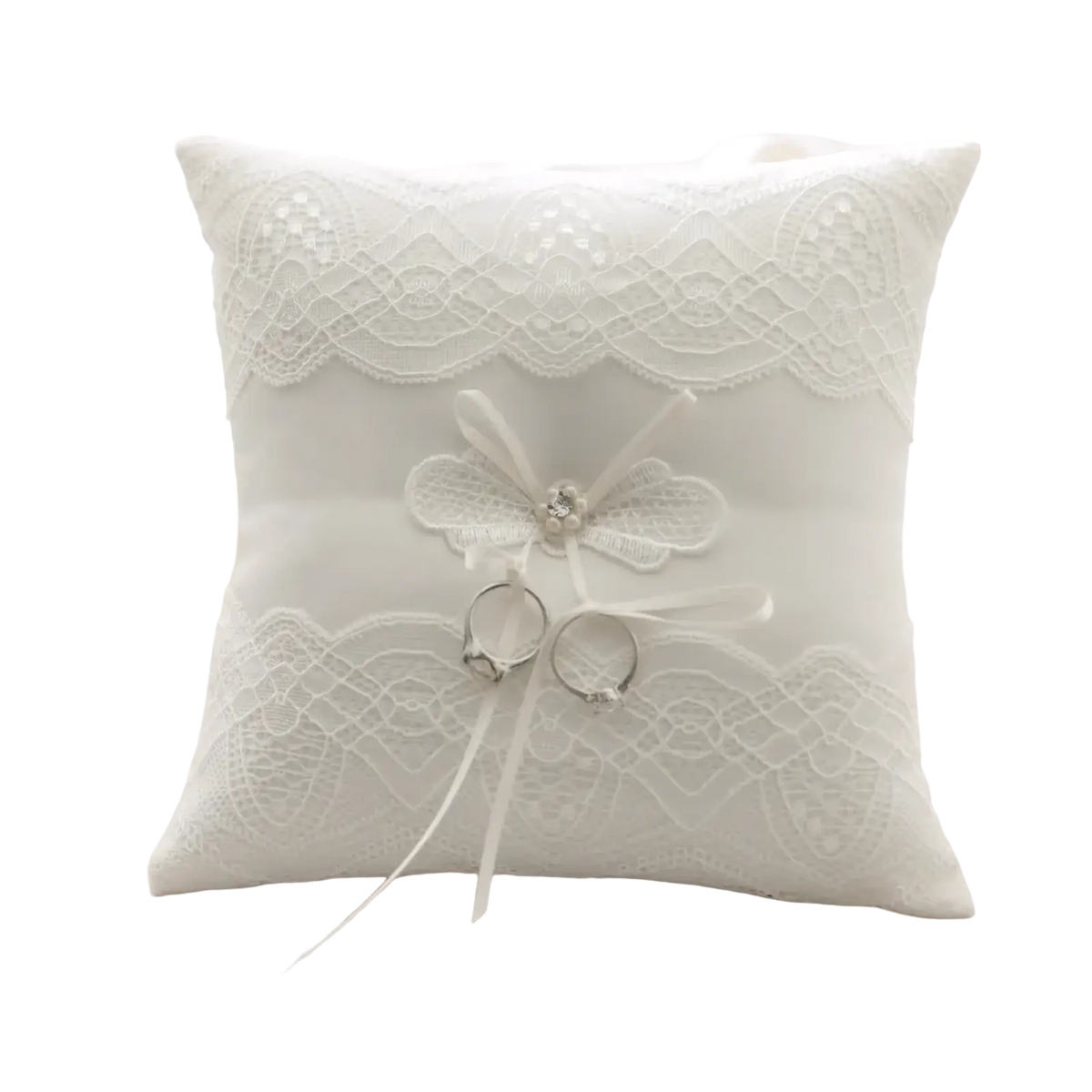 White lace wedding ring pillow with delicate floral bow and two rings nestled in soft fabric for ribbon bearer use