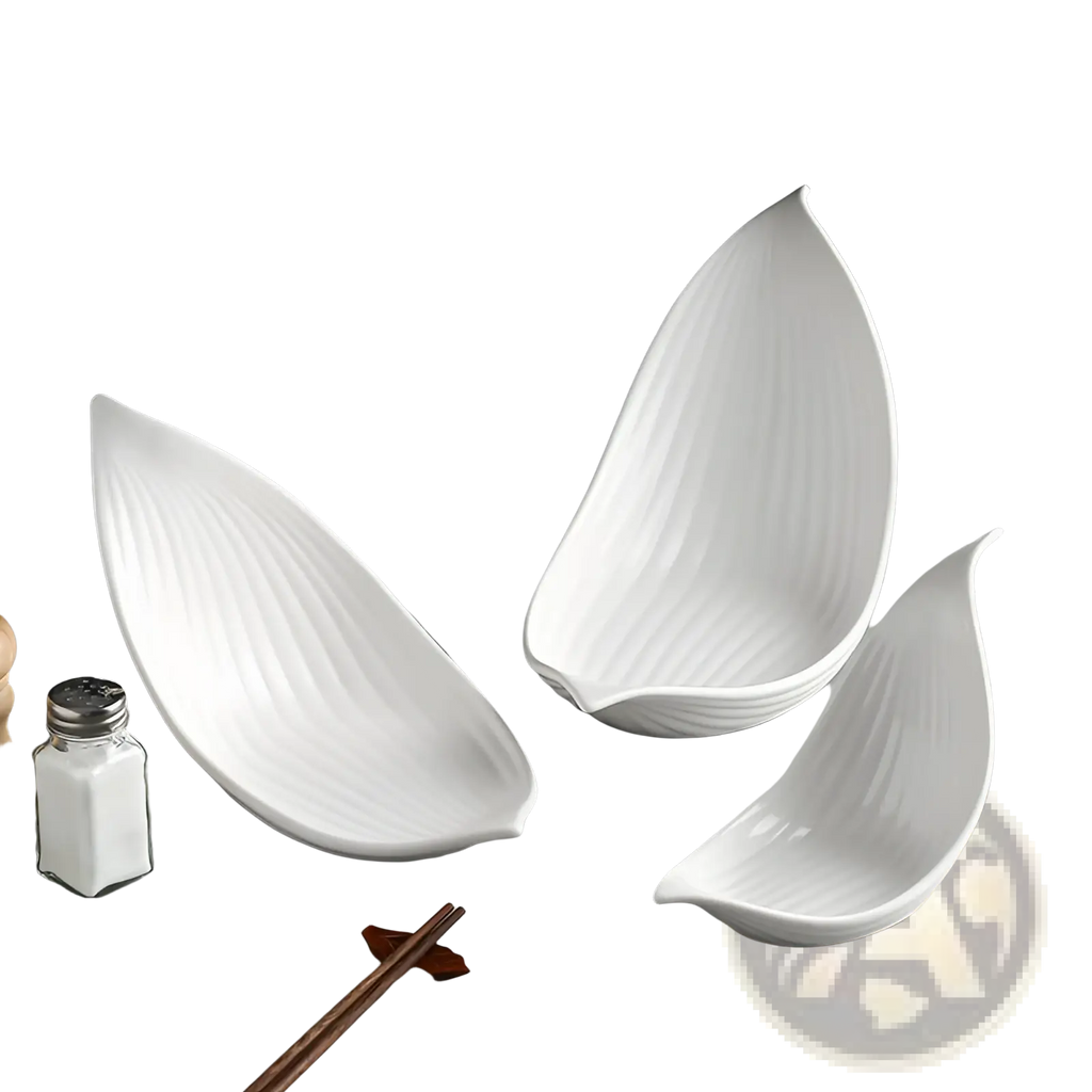 Three elegant white leaf-shaped ceramic plates with subtle vertical ridges for irregular serving dishes