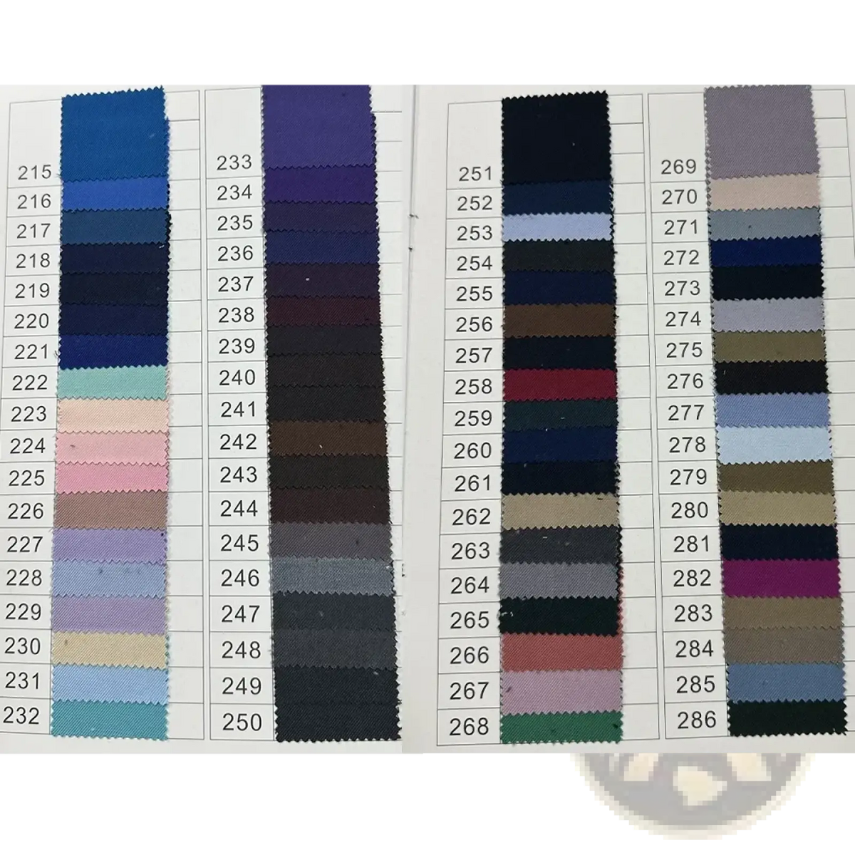 A fabric swatch book displaying various colored textile samples for a white men suit peak lapel blazer set