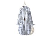 White newspaper print linen oversized shirt with long sleeves hanging on wooden hanger
