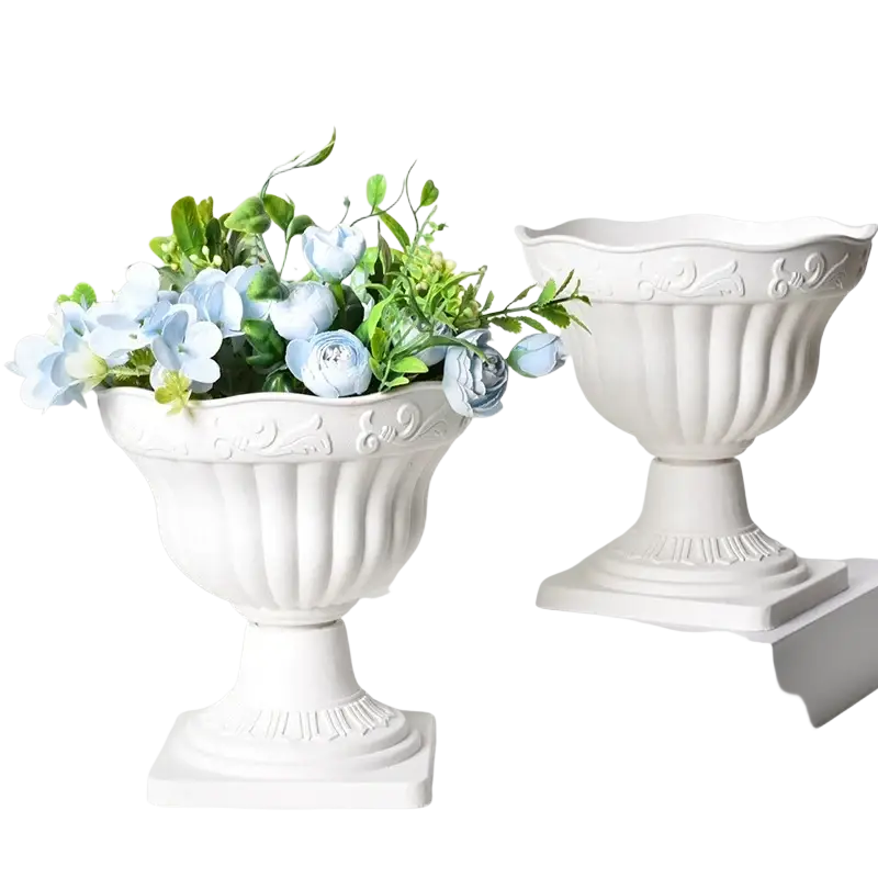 White plastic roman column planter pot with fluted sides and embossed floral detailing filled with light blue flowers