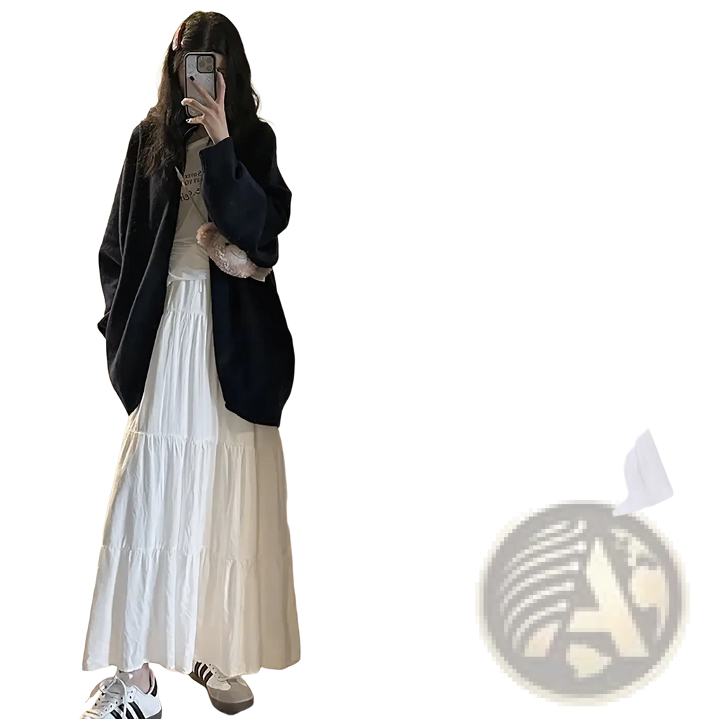 White pleated tiered maxi skirt with a high-waisted flowing design made from lightweight fabric