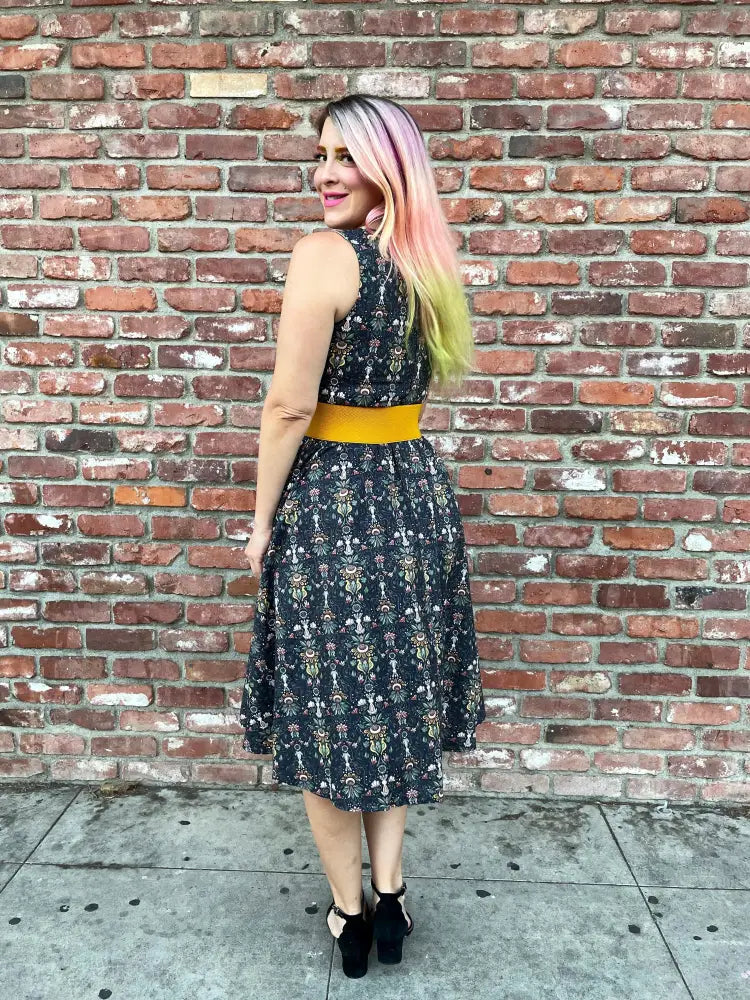 Black sleeveless midi dress with floral pattern and mustard yellow belt from White Rabbit collection